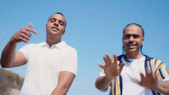 Still from the Away video: two men in summer shirts against a blue sky